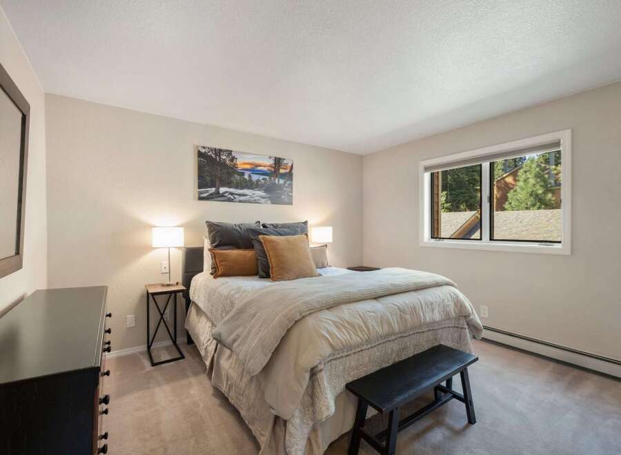 This inviting bedroom features a comfortable queen-size bed adorned with plush pillows and a cozy duvet, perfect for restful nights.