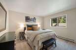 This inviting bedroom features a comfortable queen-size bed adorned with plush pillows and a cozy duvet, perfect for restful nights.