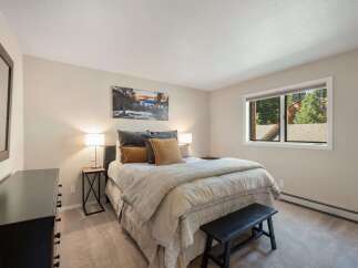 This inviting bedroom features a comfortable queen-size bed adorned with plush pillows and a cozy duvet, perfect for restful nights.