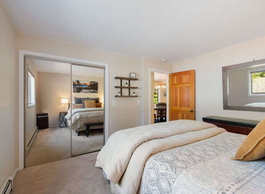 This inviting bedroom features a spacious layout with a large mirrored closet, offering ample storage and reflecting natural light.