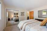 This inviting bedroom features a spacious layout with a large mirrored closet, offering ample storage and reflecting natural light.