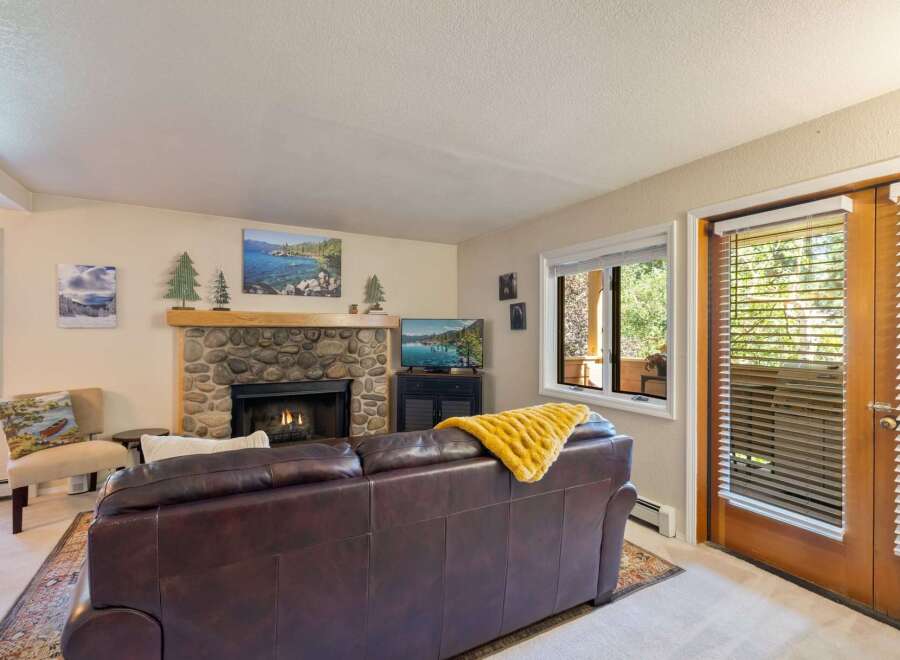 Cozy living room featuring a stone fireplace with a roaring fire, perfect for chilly evenings.