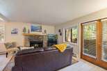 Cozy living room featuring a stone fireplace with a roaring fire, perfect for chilly evenings.