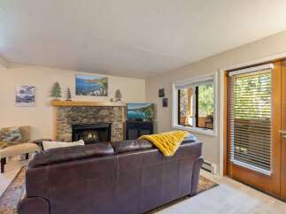 Cozy living room featuring a stone fireplace with a roaring fire, perfect for chilly evenings.