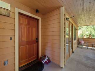 Welcome to this charming property featuring a warm and inviting entryway with a classic wooden door and a welcoming porch.