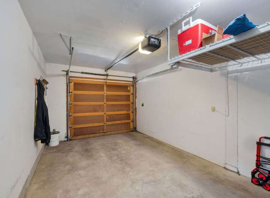 This spacious garage offers ample storage with overhead shelving, perfect for keeping your belongings organized and out of the way.