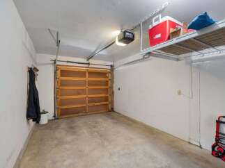 This spacious garage offers ample storage with overhead shelving, perfect for keeping your belongings organized and out of the way.