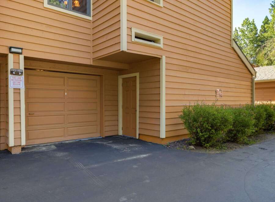 This property features a charming exterior with warm, inviting siding and a well-maintained driveway leading to a spacious garage.