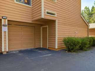 This property features a charming exterior with warm, inviting siding and a well-maintained driveway leading to a spacious garage.
