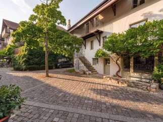 Charming property featuring a cobblestone courtyard and lush greenery, perfect for outdoor enjoyment.