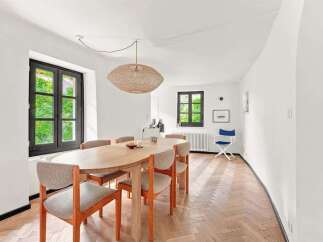 This dining room features a charming oval wooden table surrounded by upholstered chairs, perfect for intimate gatherings.