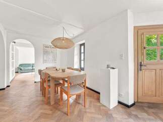 Step into this inviting dining area featuring a charming oval wooden table surrounded by four upholstered chairs with wooden frames.