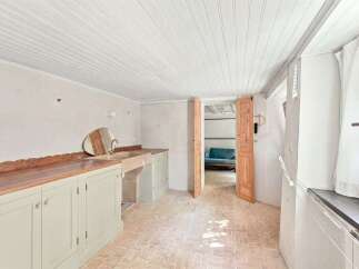 Discover a charming space featuring a large sink and ample countertop space, perfect for laundry or utility needs.