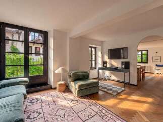 Experience modern living in this stylish apartment, featuring a spacious living area with a large rug and comfortable seating.
