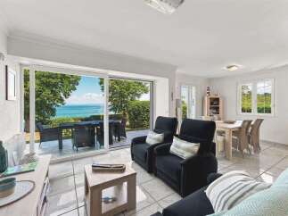 Experience breathtaking ocean views from this stunning living area, featuring a spacious glass-enclosed patio perfect for al fresco dining.