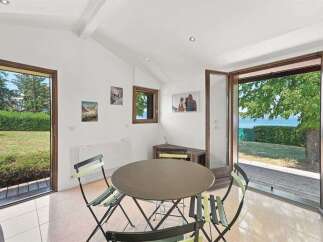 Enjoy stunning lake views from this charming room, featuring a dining area with a round table and chairs perfect for intimate meals.