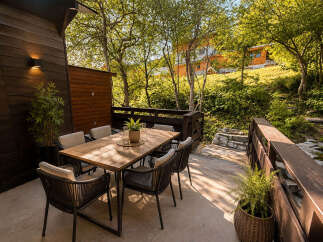 Enjoy al fresco dining on this charming wooden deck, complete with a stylish outdoor dining set perfect for entertaining.