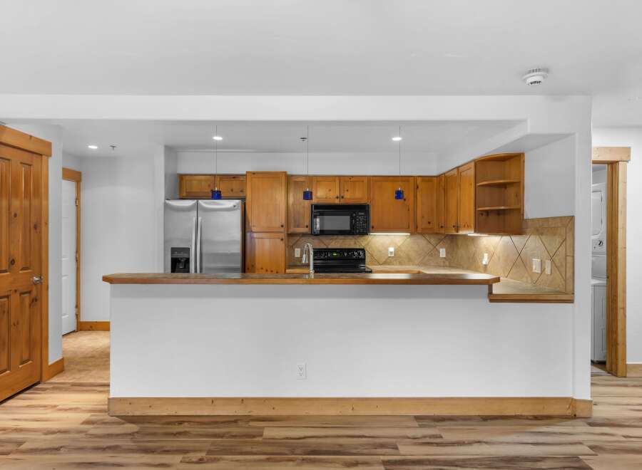 Discover this charming kitchen featuring warm wooden cabinetry and a sleek stainless steel refrigerator.