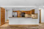 Discover this charming kitchen featuring warm wooden cabinetry and a sleek stainless steel refrigerator.