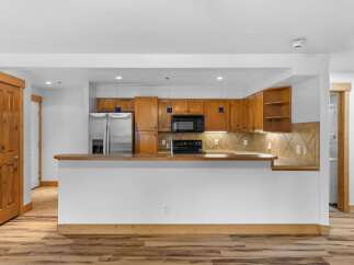 Discover this charming kitchen featuring warm wooden cabinetry and a sleek stainless steel refrigerator.