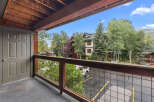 Enjoy the fresh mountain air from this charming balcony, offering a serene view of the surrounding trees and architecture.