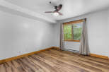 This room features a modern ceiling fan and a large window with blinds, offering ample natural light.