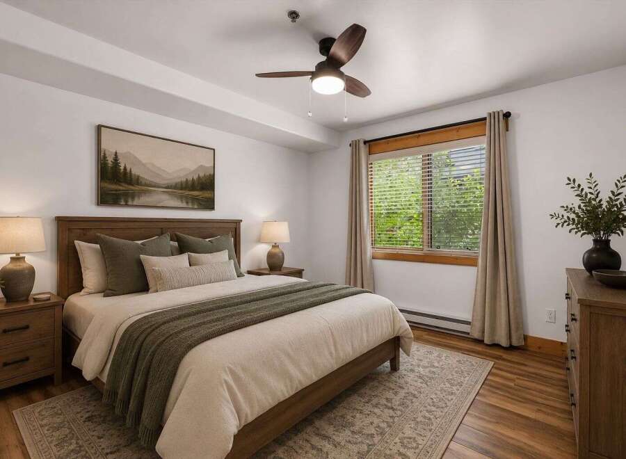Experience serene mountain living in this charming bedroom, featuring a comfortable queen-size bed adorned with plush pillows and a cozy knit throw.