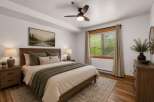 Experience serene mountain living in this charming bedroom, featuring a comfortable queen-size bed adorned with plush pillows and a cozy knit throw.