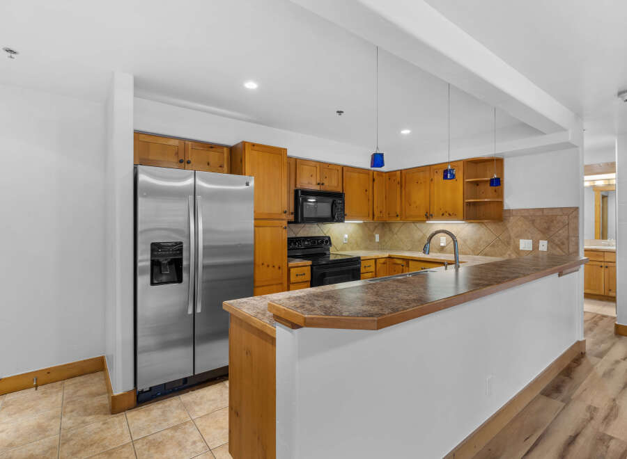 This spacious kitchen features warm wooden cabinetry and a sleek stainless steel refrigerator.