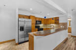 This spacious kitchen features warm wooden cabinetry and a sleek stainless steel refrigerator.