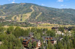 Nestled amidst lush greenery and towering trees, this property offers a serene mountain retreat with stunning views of ski slopes and surrounding peaks.