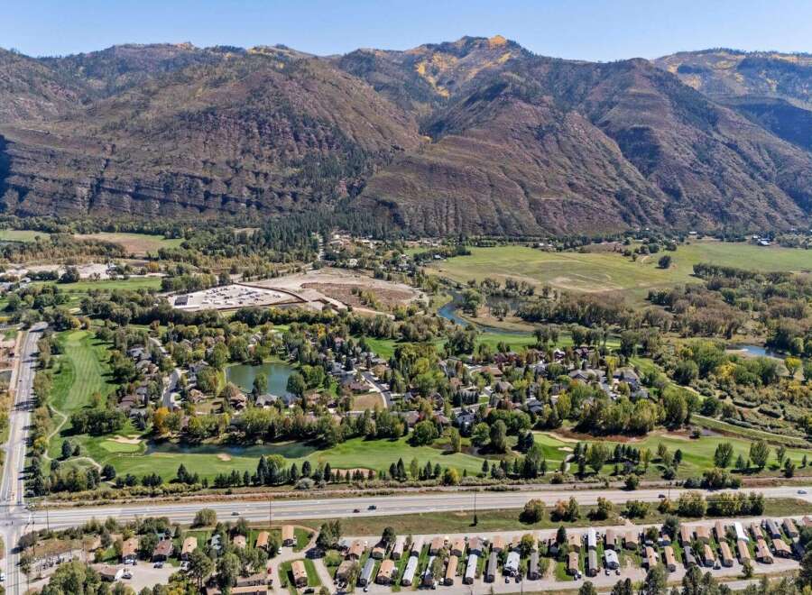 Discover this stunning property nestled against majestic mountains, offering a picturesque golf course community with serene water features.