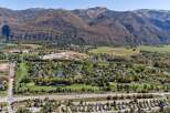 Discover this stunning property nestled against majestic mountains, offering a picturesque golf course community with serene water features.