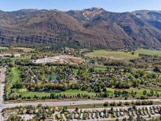 Discover this stunning property nestled against majestic mountains, offering a picturesque golf course community with serene water features.