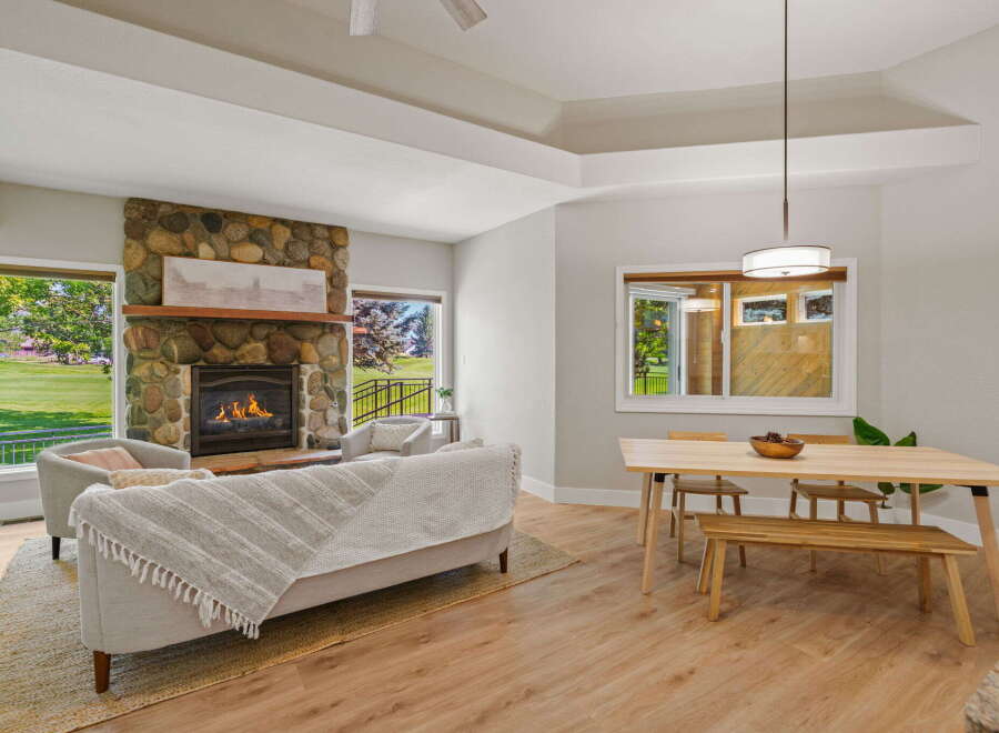 Experience comfortable living in this inviting open-concept space, featuring a stunning stone fireplace as the centerpiece of the living area.
