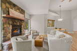 Cozy living room featuring a striking floor-to-ceiling stone fireplace with a rustic wooden mantel.