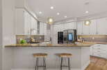 This modern kitchen boasts sleek white cabinetry and a stunning granite countertop, perfect for entertaining.