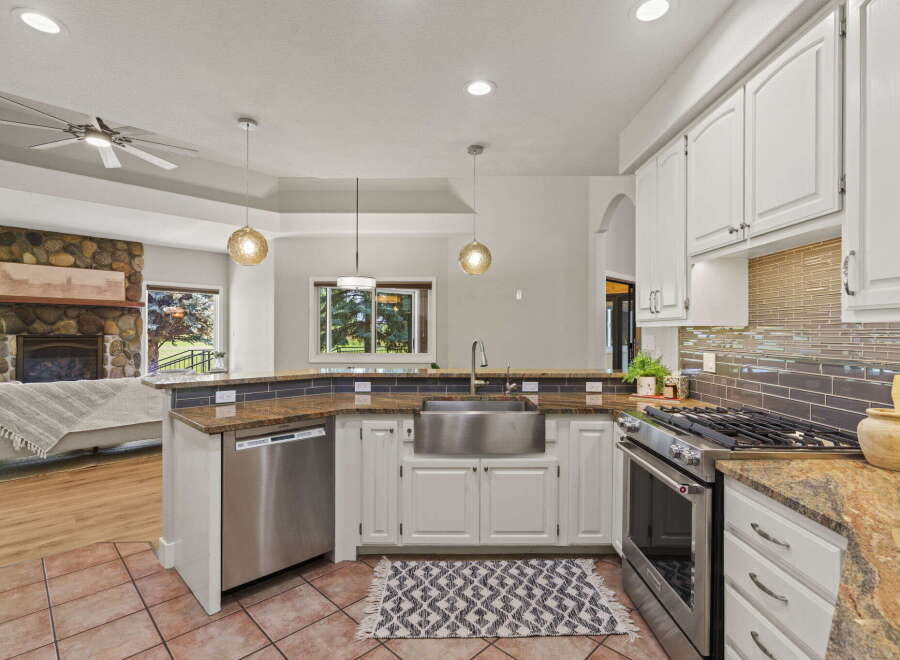 This spacious kitchen boasts a large stainless steel farmhouse sink, perfect for any culinary enthusiast.