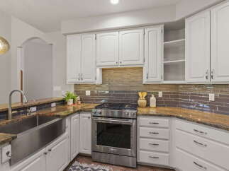 This stunning kitchen boasts a sleek stainless steel farmhouse sink and a professional-grade gas range, perfect for any home chef.
