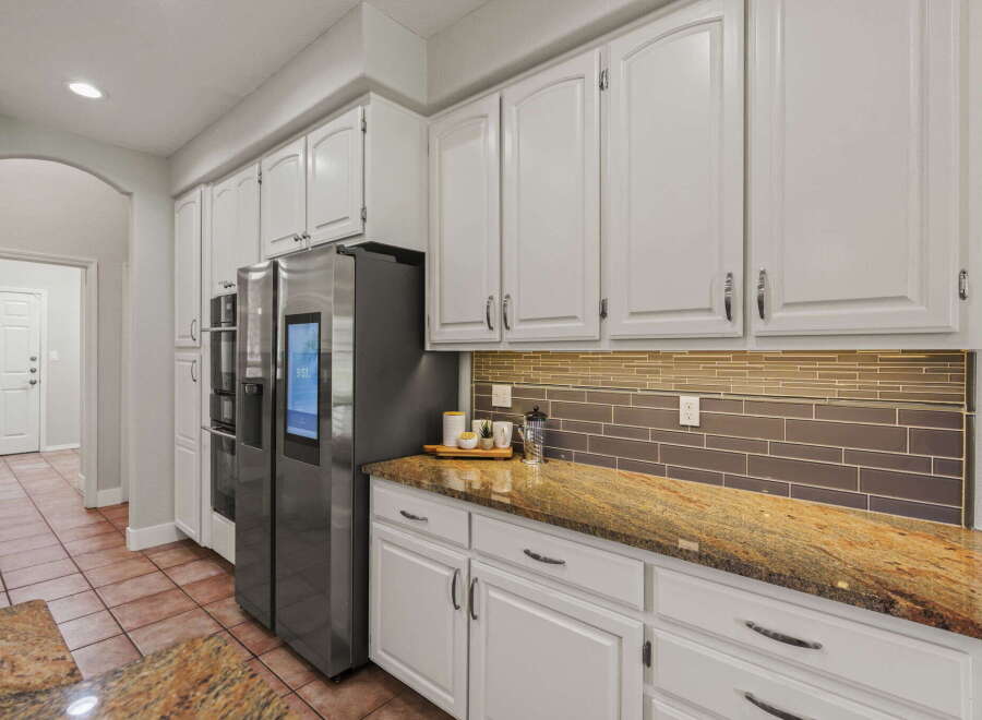 Step into this stunning kitchen featuring sleek white cabinetry and a beautiful granite countertop that adds a touch of elegance.