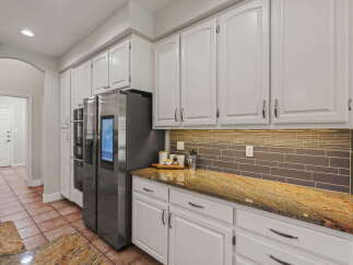 Step into this stunning kitchen featuring sleek white cabinetry and a beautiful granite countertop that adds a touch of elegance.