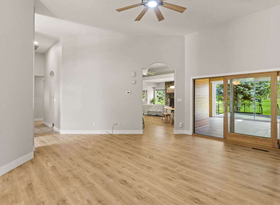 Step into this inviting living space featuring high vaulted ceilings and a modern ceiling fan for optimal comfort.