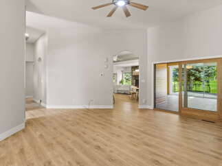 Step into this inviting living space featuring high vaulted ceilings and a modern ceiling fan for optimal comfort.