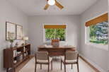 This home office features a spacious wooden desk with a laptop and two chairs, perfect for productivity.