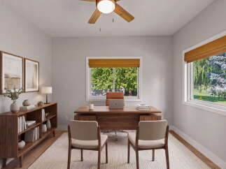 This home office features a spacious wooden desk with a laptop and two chairs, perfect for productivity.