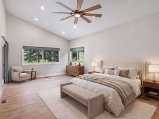 Experience luxury and comfort in this stunning bedroom, featuring a vaulted ceiling with a modern fan and recessed lighting.