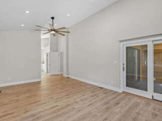 Experience spacious living in this modern home featuring a vaulted ceiling and a stylish ceiling fan.