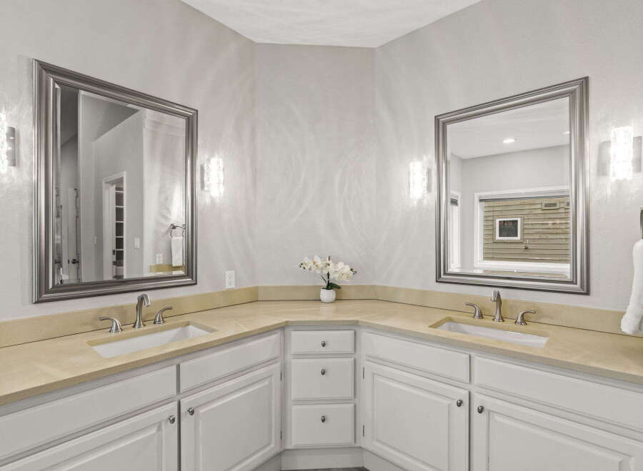 This elegant bathroom features a spacious double vanity with a light-colored countertop and two undermount sinks, perfect for busy mornings.