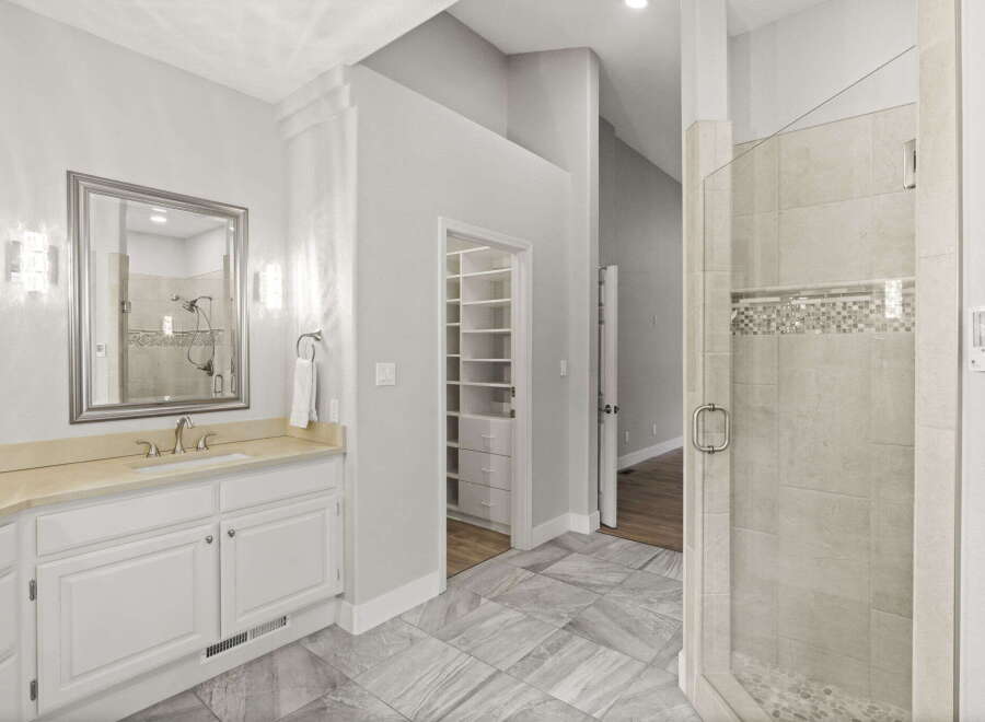 Experience luxury in this spacious bathroom featuring a large vanity with ample counter space and a sleek undermount sink.