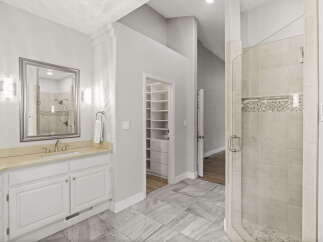 Experience luxury in this spacious bathroom featuring a large vanity with ample counter space and a sleek undermount sink.